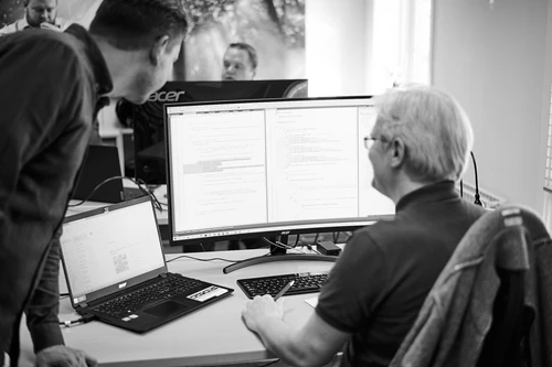 Billede af medarbejder ved computer der snakker om App-udvikling og Umbraco CMS eller softwareudvikling